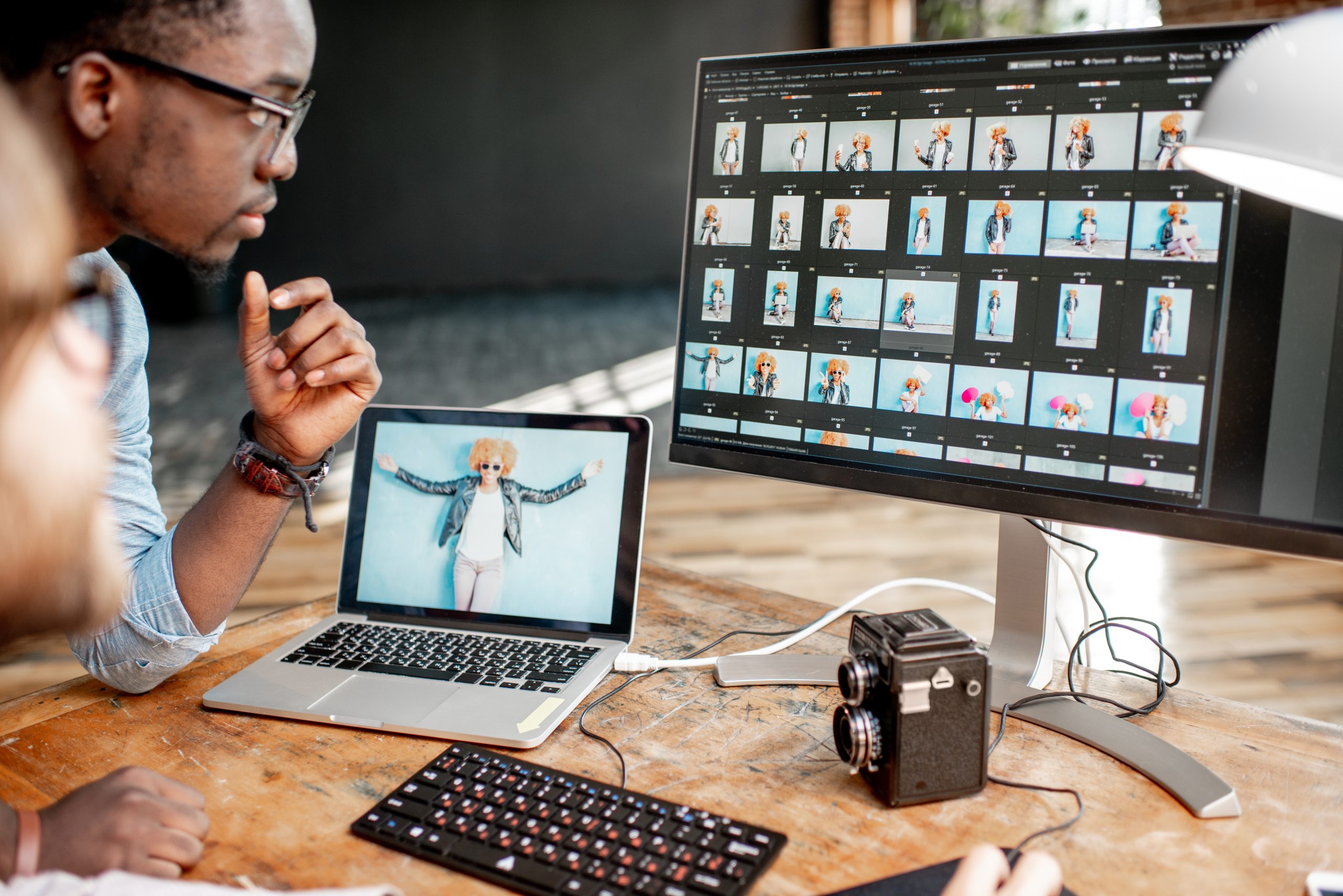 Two photographers working on the computers in the studio